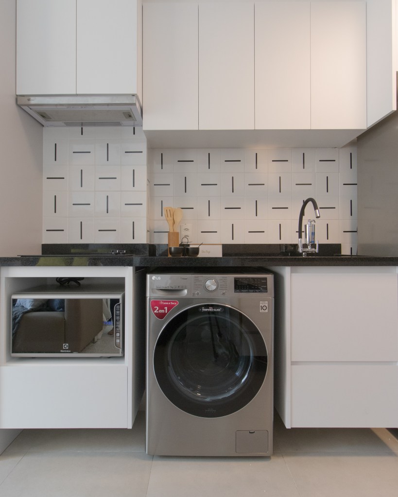 Apartamento pequeno de 29 m² possui lavanderia, home office e cama de casal, Projeto de Letícia de Nóbrega. Na foto, cozinha com lavanderia.