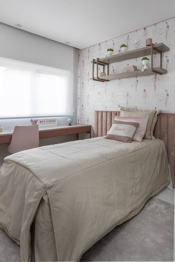 Quarto infantil de menina com papel de parede de flores e cabeceira acolchoada rosa.