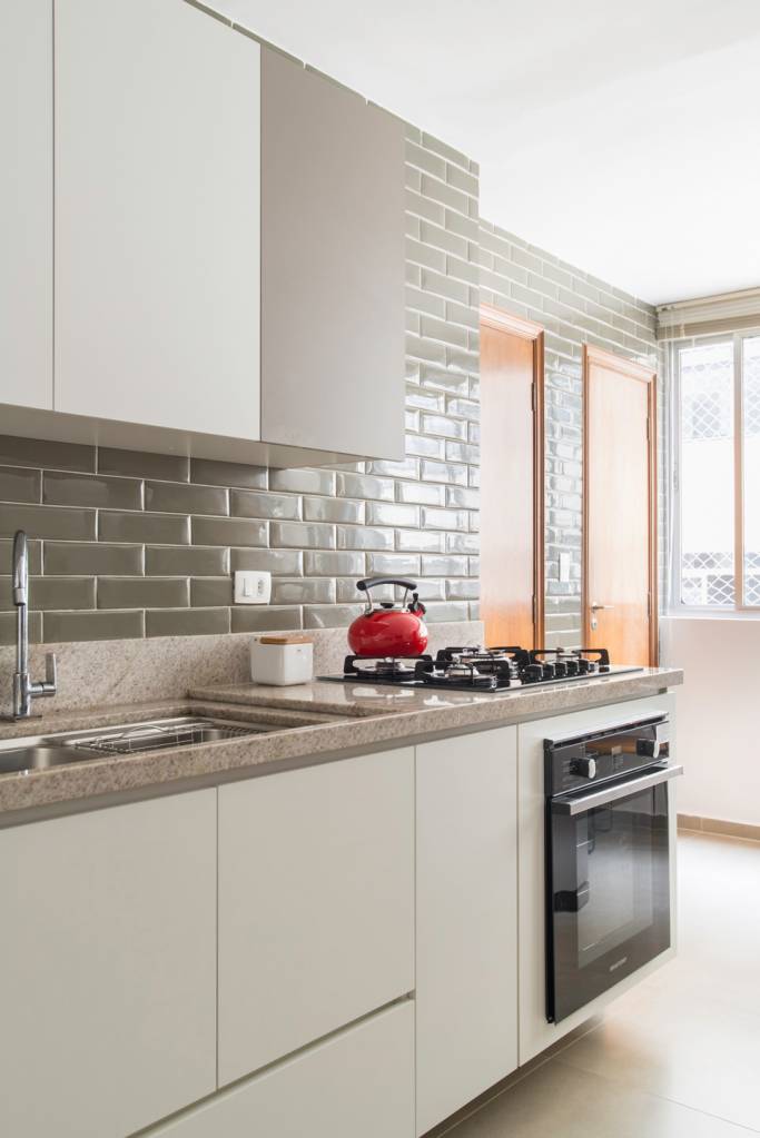 bancada-de-cozinha-materiais-vantagens-desvantagens-raizes-arquitetos-02 Cozinha com bancada de granito, marcenaria branca e revestimento de tijolinhos.