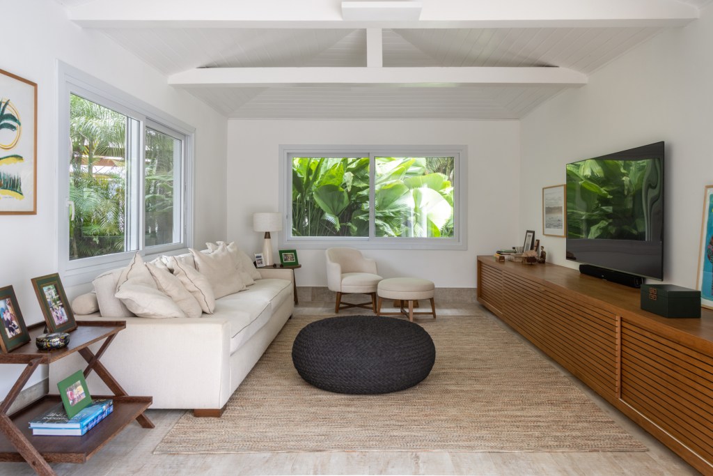 casa-guaruja-600-m2-jardim-tropical-piscina-prainha-stal-arquitetura-credito-evelyn-muller (21) Casa no Guarujá de 600 m² tem jardim tropical e piscina com prainha. Projeto Stal Arquitetura. Na foto, sala de TV com vista para o jardim.