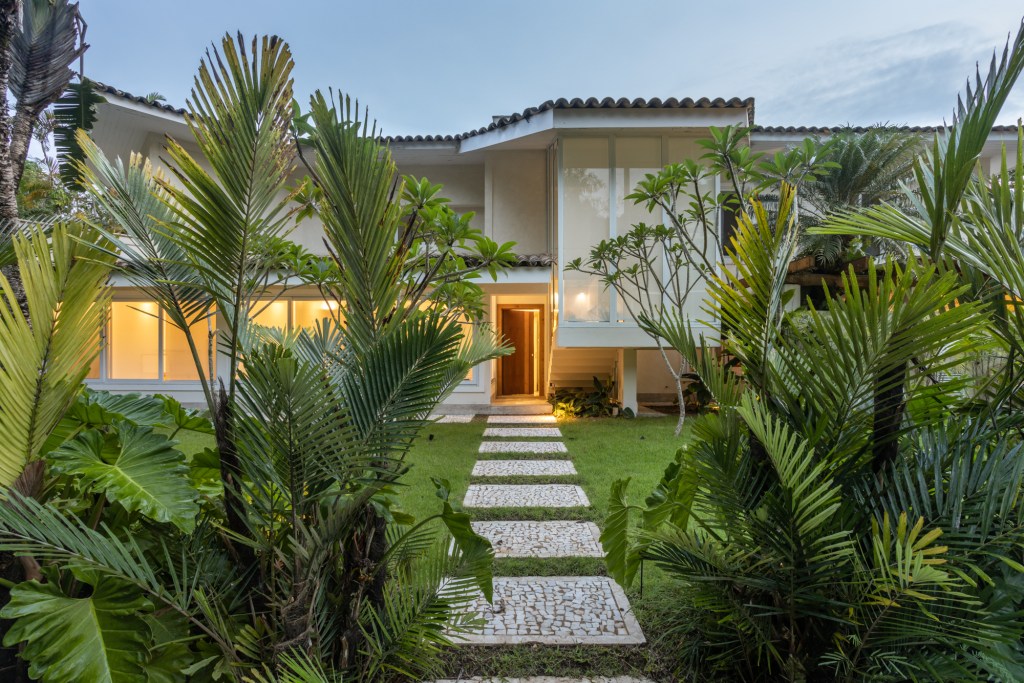 Casa no Guarujá de 600 m² tem jardim tropical e piscina com prainha. Projeto Stal Arquitetura. Na foto, fachada com jardim.