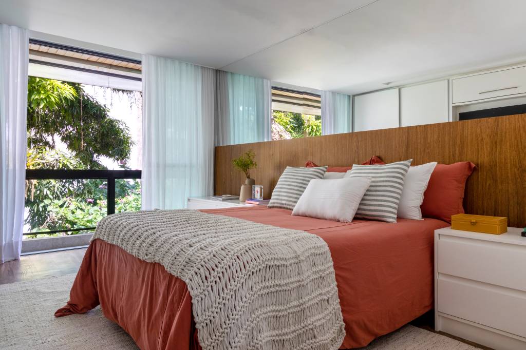 cobertura-triplex-160m-terraco-banco-azulejos-manuela-santos-paula-scholte-23-quarto Quarto com cama de casal, cabeceira de madeira e espelho atrás da cama.