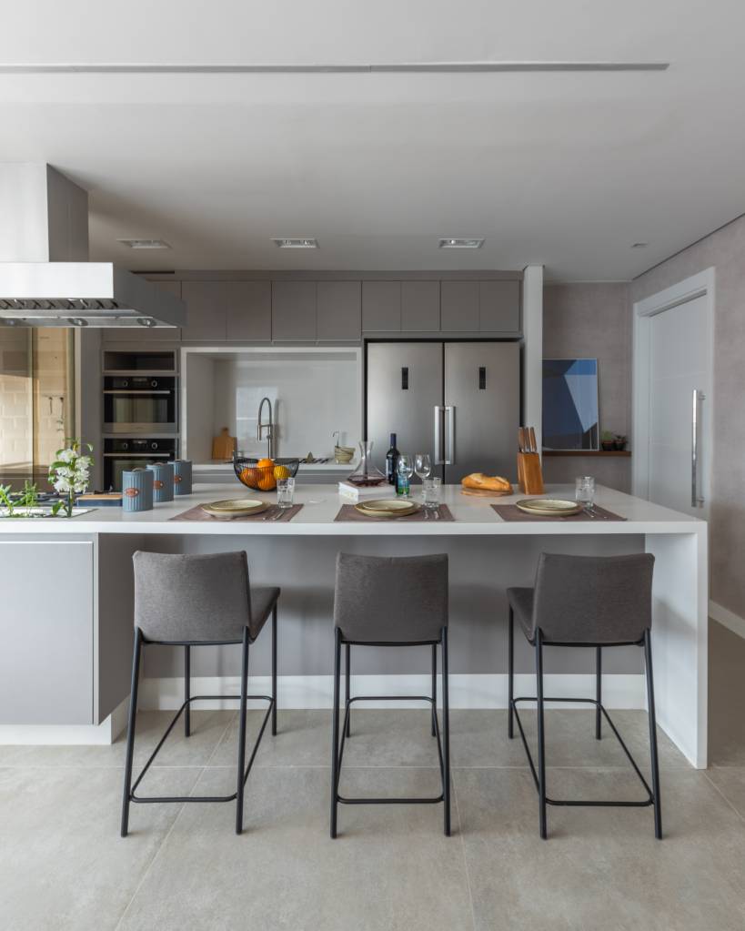 como-usar-cor-cinza-na-decoracao-bruno-moraes-arquitetura-01 Cozinha com marcenaria cinza, piso de porcelanato e banquetas cinzas.