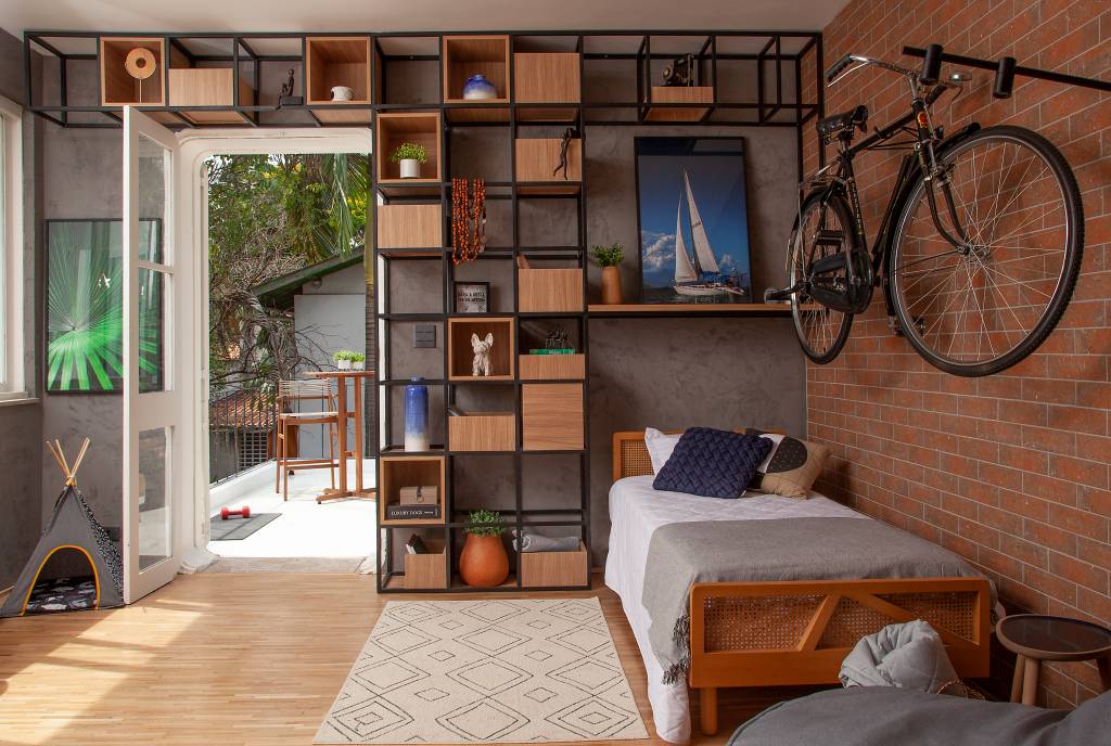 como-usar-cor-cinza-na-decoracao-bruno-moraes-arquitetura-05 Quarto com estante vazada com nichos e parede cinza.