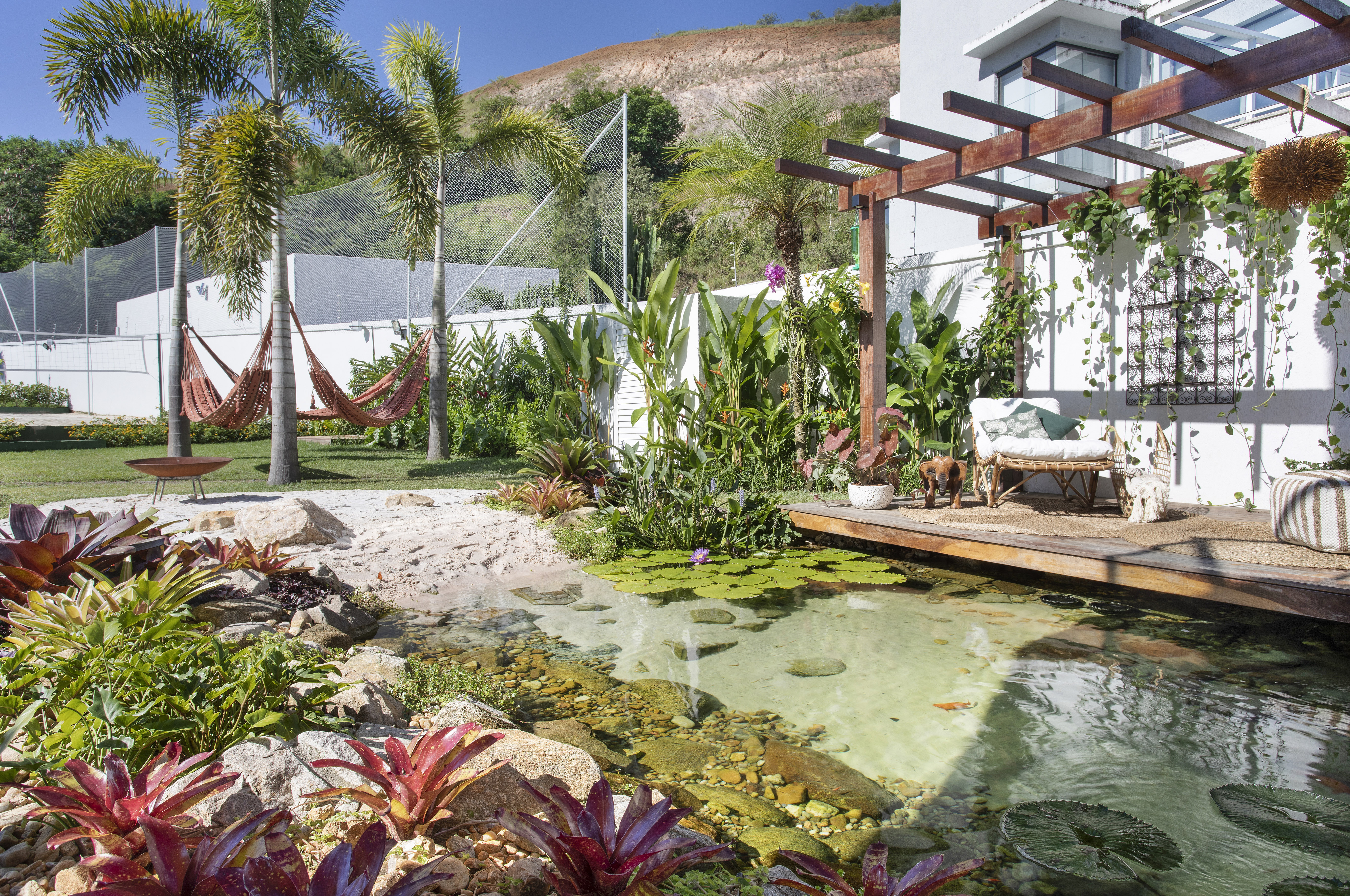 Jardim tropical de 900m² tem lago de peixes, pergolado e horta