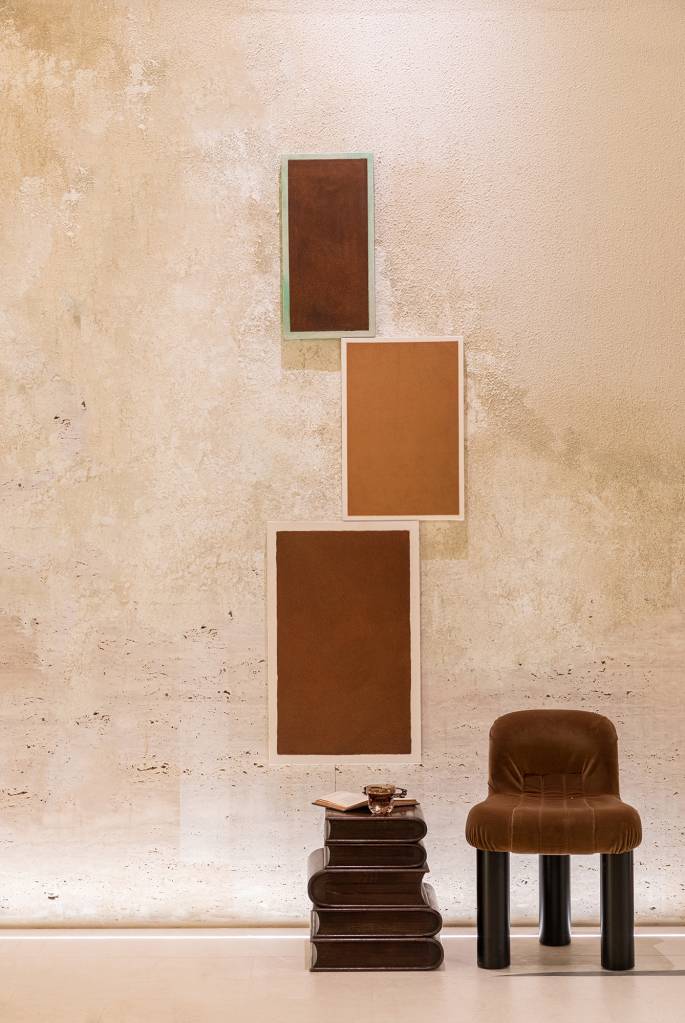 Marcas do tempo e histórias marcam o décor deste loft. Projeto de SUITE Arquitetos para a CASACOR SP 2023. Na foto, obras de arte e cadeira.