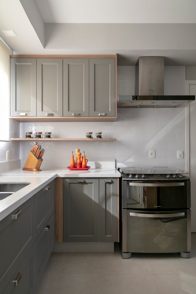 Cozinha em estilo clássico com armários na cor cinza e bancada branca.
