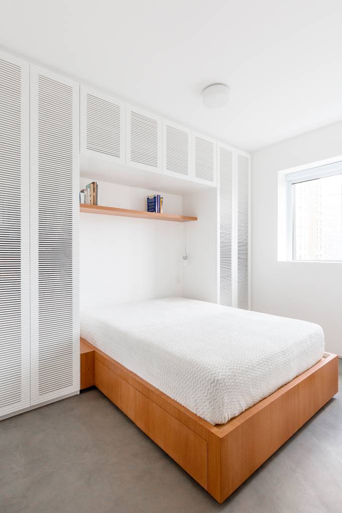 Móvel que pode ser usado como sofá, cama ou chaise setoriza apê de 64 m². Projeto VAGA Arquitetura. Na foto, quarto com armarios ripados.