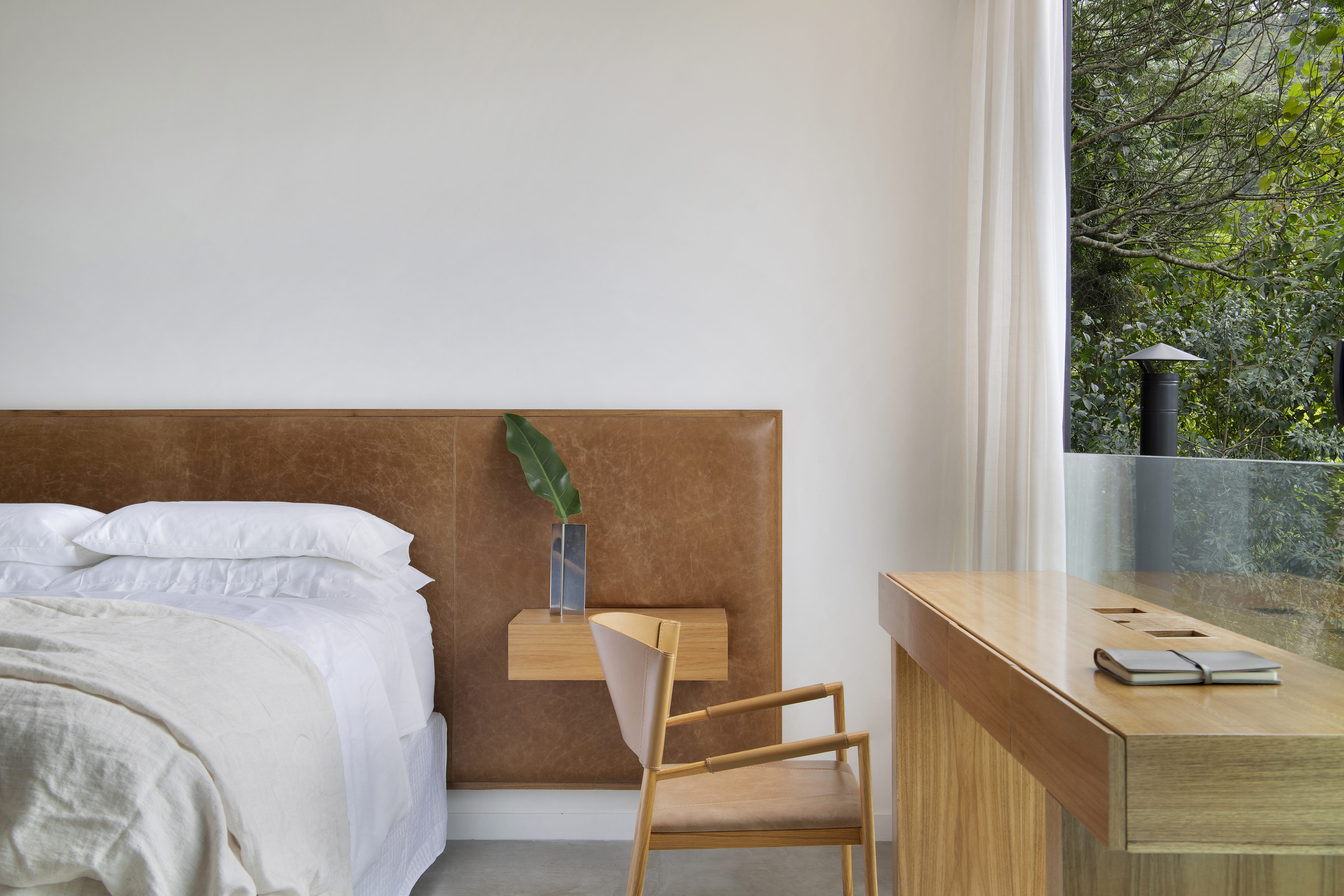 Quarto com cama de casal, cabeceira de couro e home office