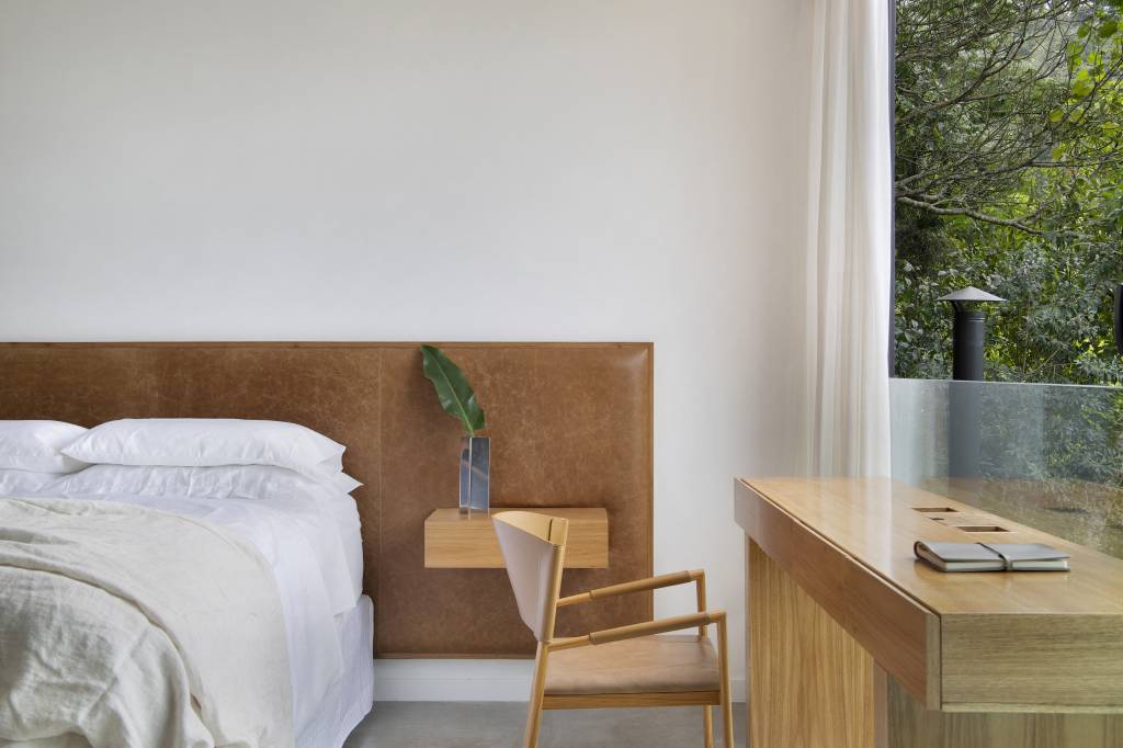 Quarto com cama de casal, cabeceira de couro e home office