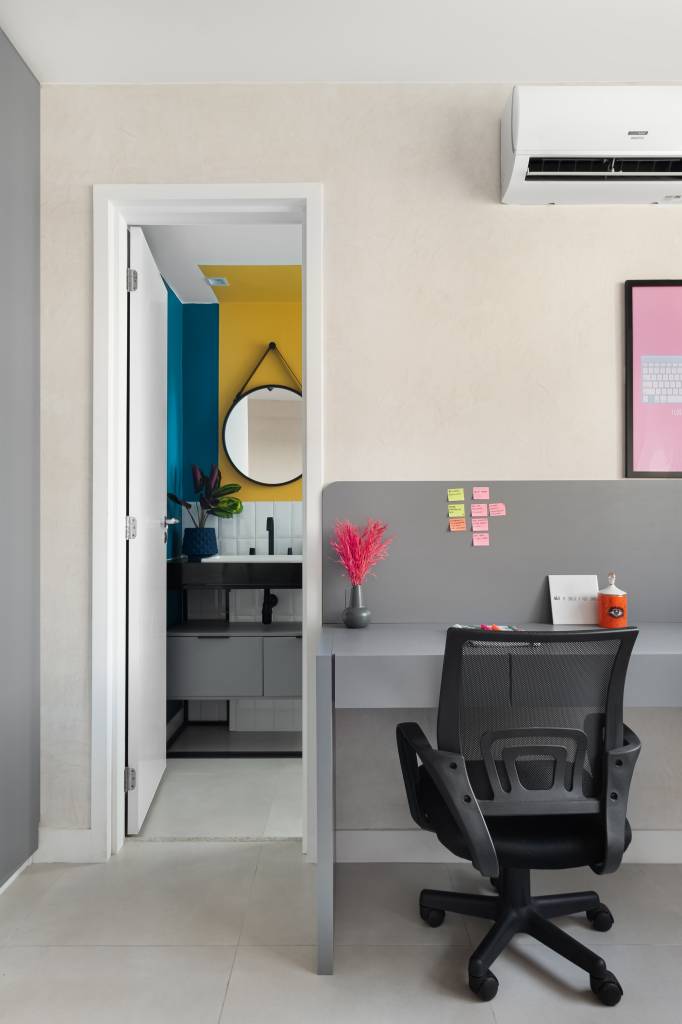 apartamento-colorido-65-m2-cheio-referencias-pop-art-pistache-arquitetura-credito-studio-tree-fotografia (10) Apartamento colorido de 65 m² é cheio de referências ao pop art. Projeto de Pistache Arquitetura. Na foto, escritório com bancada cinza, Banheiro com parede amarela e azul e espelho redondo.