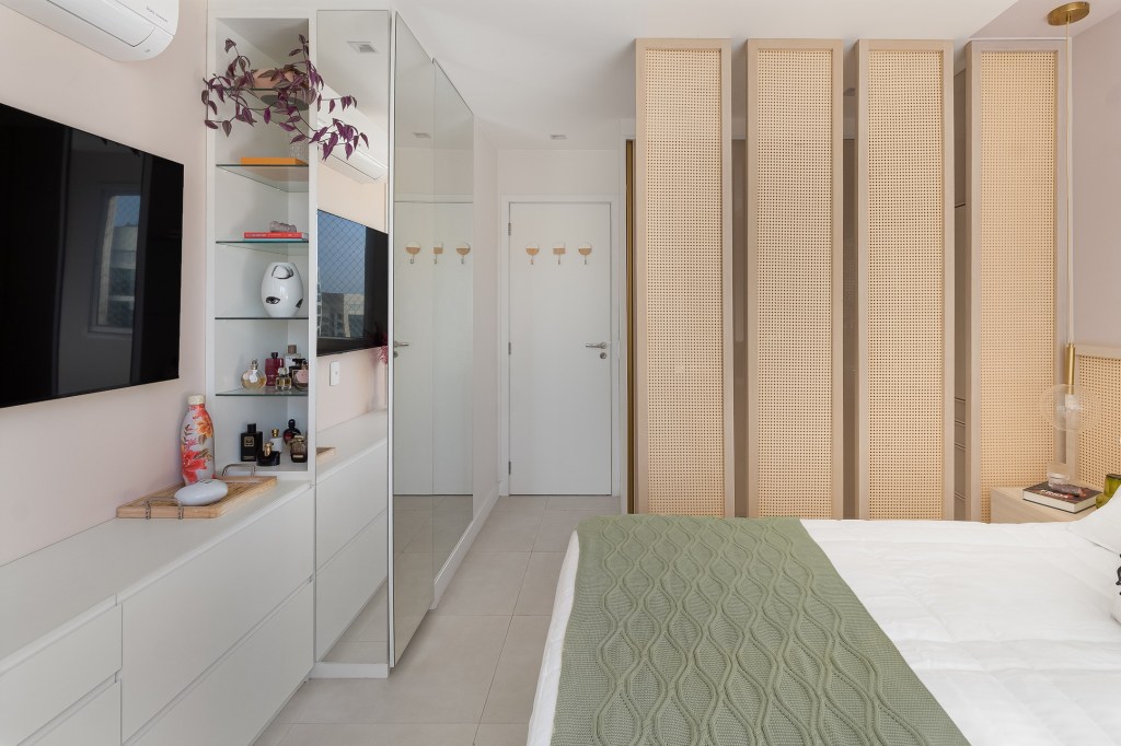 Apartamento colorido de 65 m² é cheio de referências ao pop art. Projeto de Pistache Arquitetura. Na foto, quarto com armário de palhinha, cama e espelho.