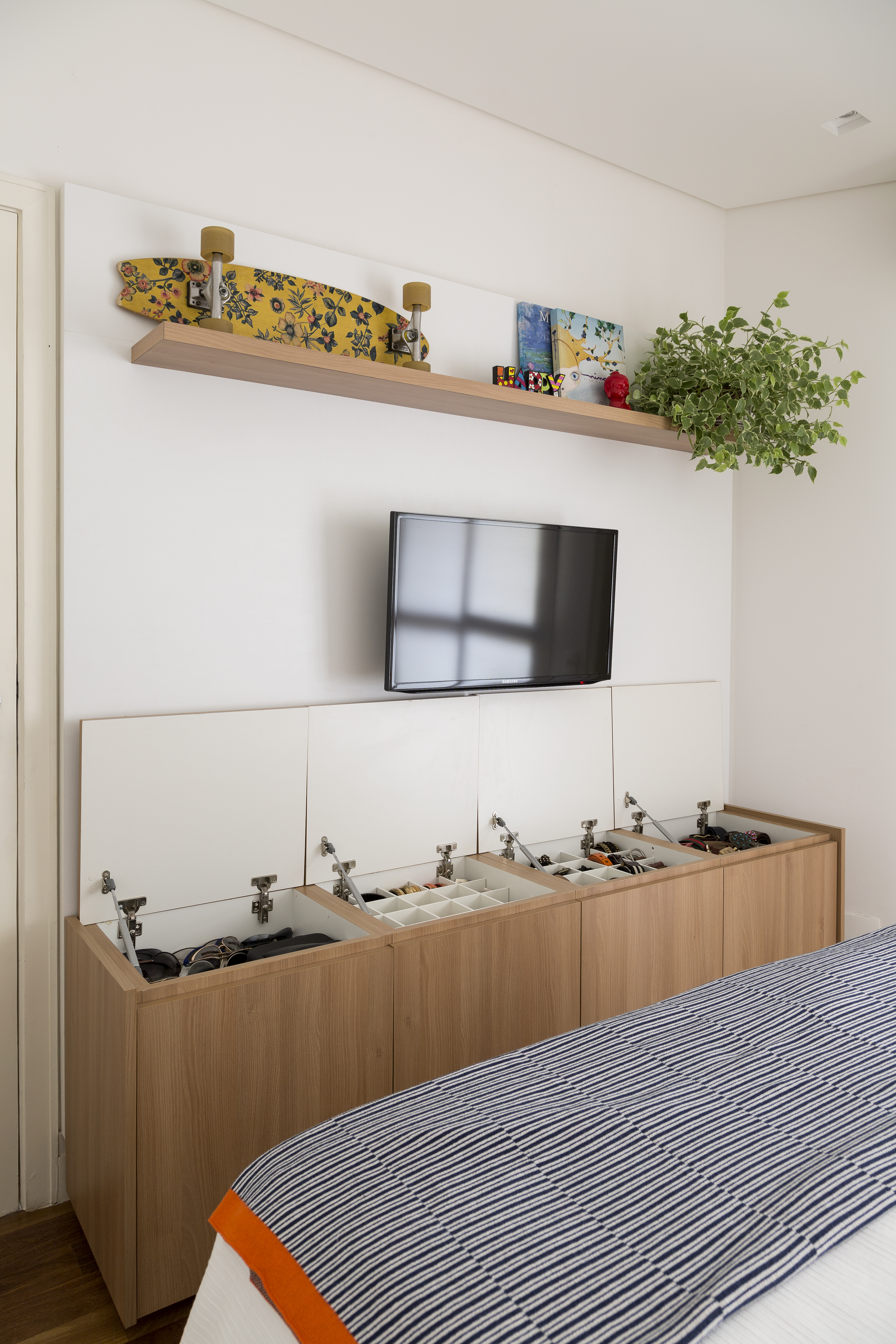 Quarto com móvel multifuncional que funciona como bancada e armário.