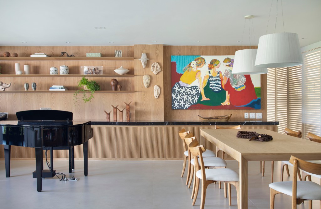 Sala de estar com parede revestida de madeira com persianas, quadro e piano.
