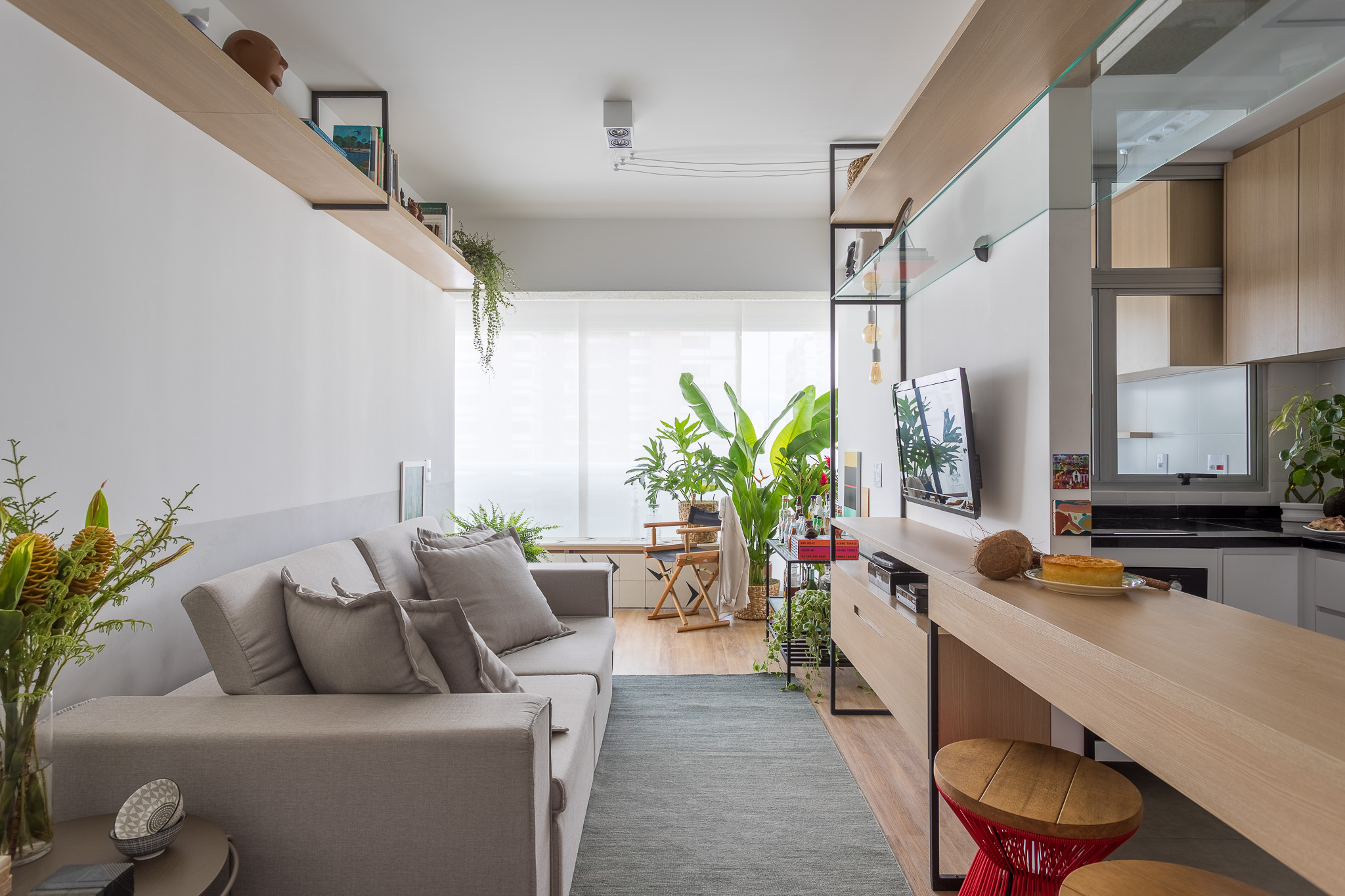 Sala de estar pequena integrada com cozinha e varanda.