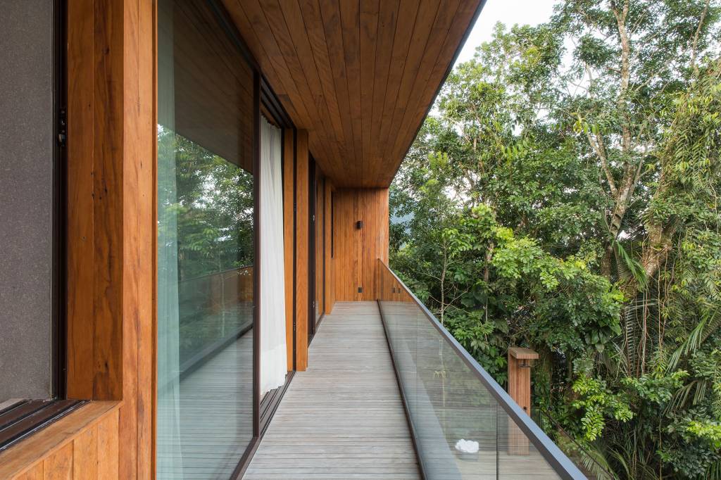 Casa de 153 m² se camufla em meio à natureza do litoral paulista. Projeto de Daniel Fromer, interiores de Julyana Bortolotto. Na foto, varanda dos quartos com vista para a mata.