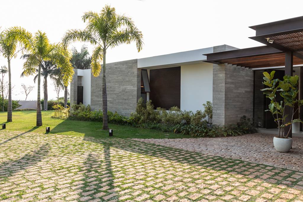 Casa de campo térrea tem vista para o laranjal e espaço para shuffleboard. Projeto de Gilda Meirelles. Na foto, fachada da casa com jardim.