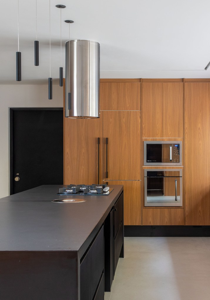 casa-modernista-900m-cozinha-integrada-moveis-design-murad-sarria-arquitetura-renata-zappellini-18 Cozinha integrada com ilha preta e bancada preta.