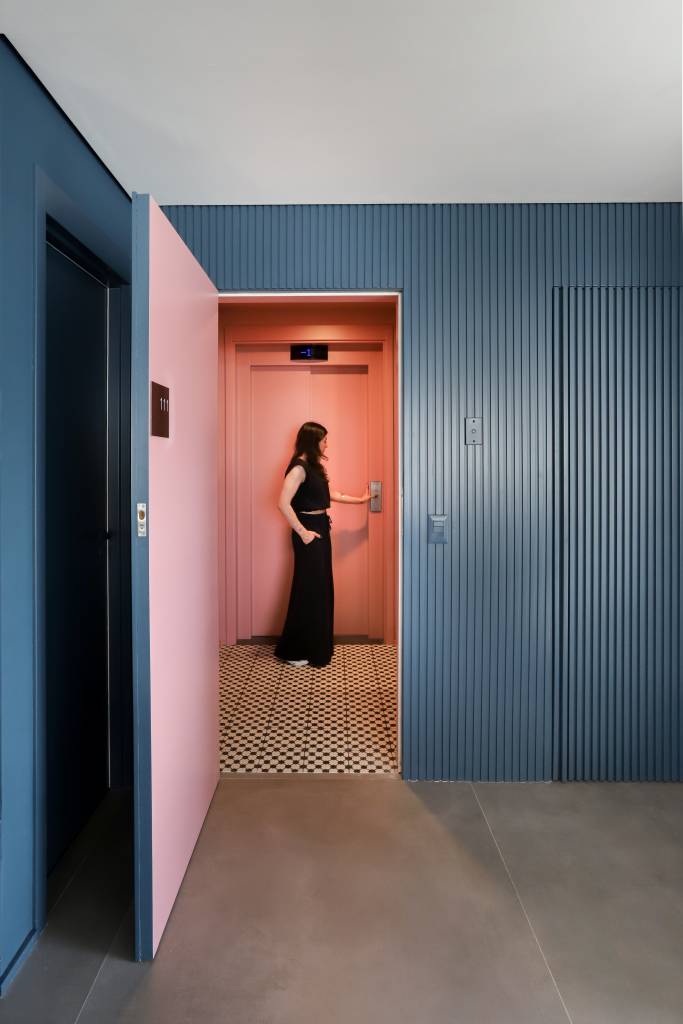 Hall de entrada com color blocking rosa. Paredes azuis do lado de fora.