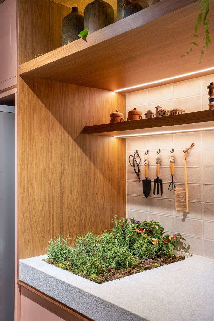 Cozinha une marcenaria rosa, brises, horta e granito branco. Projeto de Bruno Moraes para a CASACOR SP 2023. Na foto, cozinha com horta na bancada da pia. Marcenaria rosa.