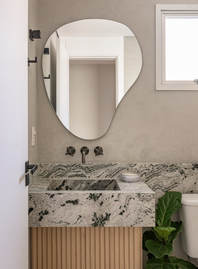 Cozinha verde mint e mesa de trabalho em destaque marcam este apê de 90 m². Projeto Suellen Figueiredo. Na foto, banheiro com pia de marmore e espelho orgânico.