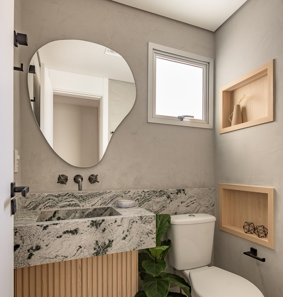 Cozinha verde mint e mesa de trabalho em destaque marcam este apê de 90 m². Projeto Suellen Figueiredo. Na foto, banheiro com pia de marmore e espelho orgânico.