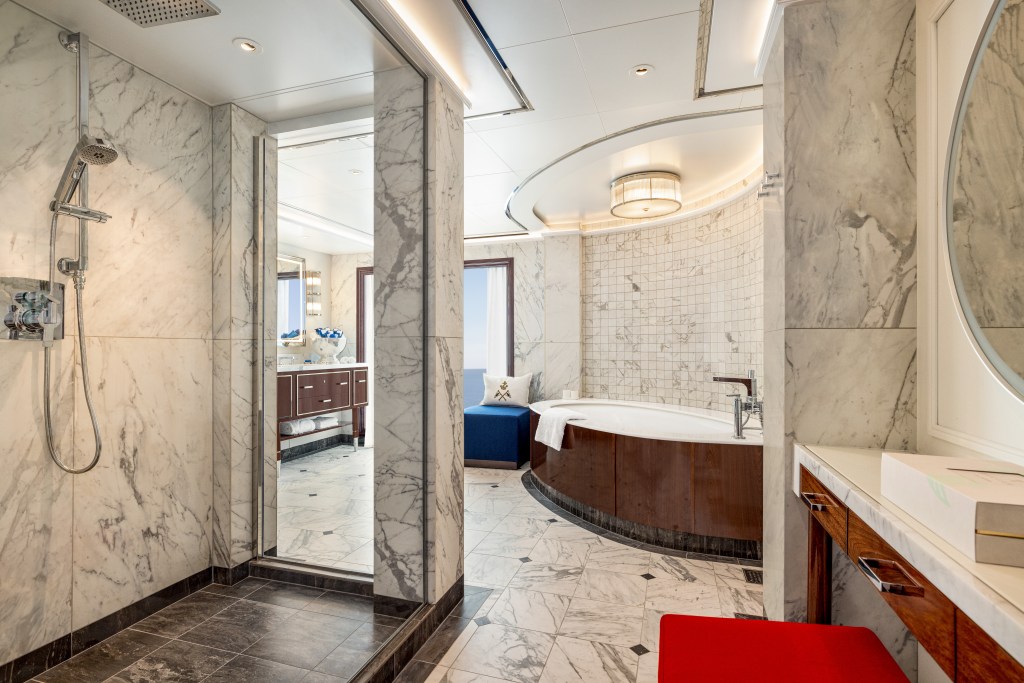 Banheiro com paredes marmorizadas e banheira de imersão.