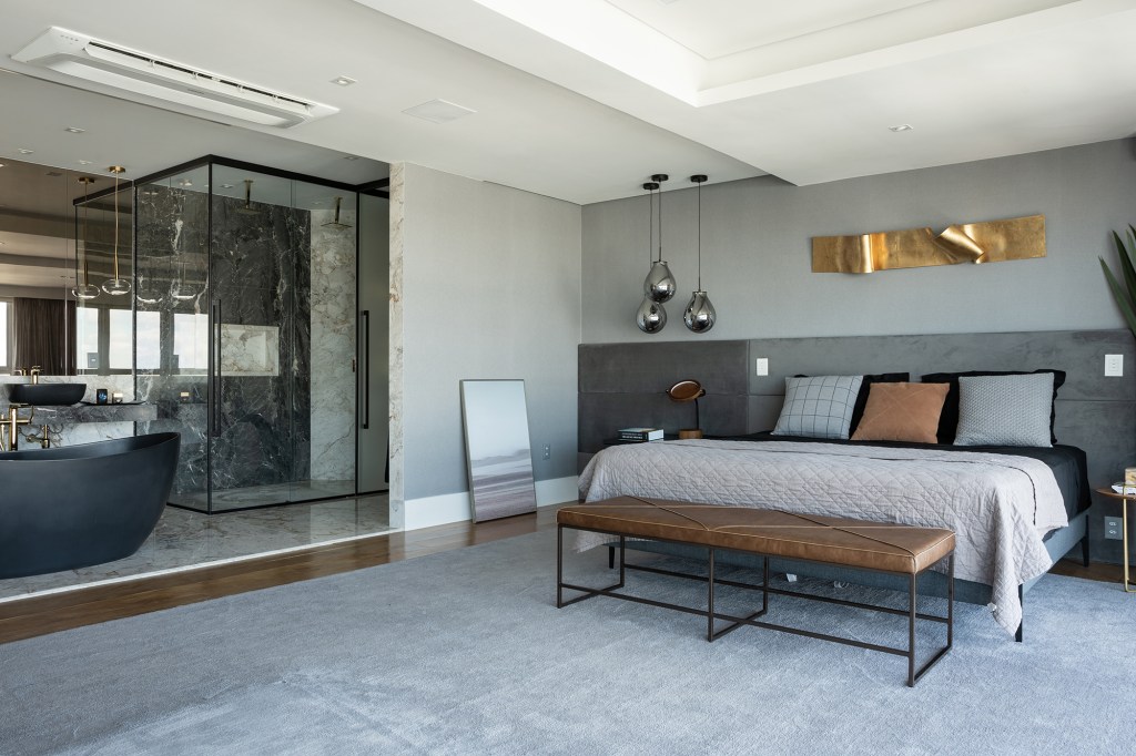 Duplex de 300 m² possui eletrodomésticos camuflados e vista para a cidade. Projeto de Silvana Lara Nogueira com móveis da Florense. Na foto, quarto de casal com cama, luminária e tapete.