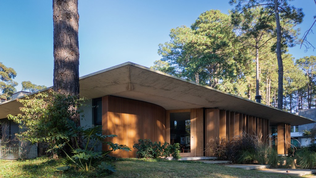 Layout minimalista marca casa térrea de 201 m² no Rio Grande do Sul. Projeto de Stemmer Rodrigues Arquitetura. Na foto, fachada da casa em meio ao jardim.