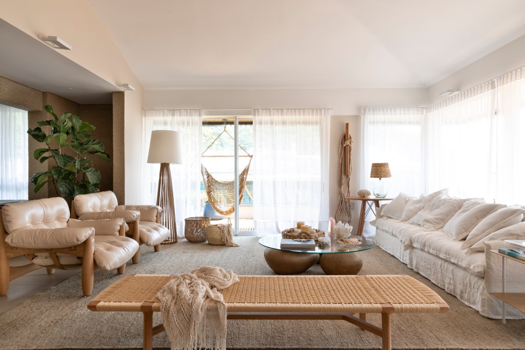 Sala de estar com decoração clean, cortina branca, sofá branco e duas poltronas Moles.