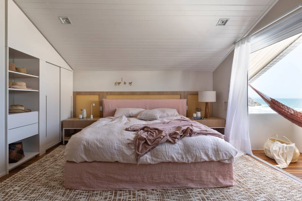 materiais-naturais-clima-praia-ape-alessandra-ambrosio-juliana-pippi-16-quarto Quarto com varanda, cama de casal e cabeceira de palhinha.