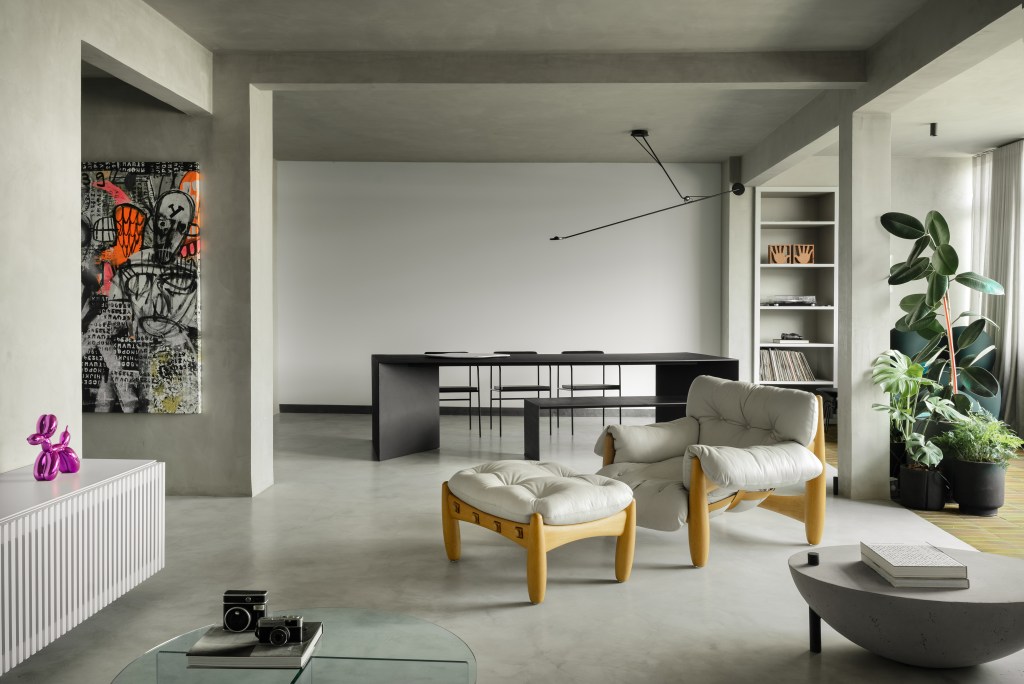 Minimalista: apê de 300 m² utiliza poucas cores e efeitos de luz no décor. Projeto de Lucas Lage. Na foto, sala de estar e jantar preto e branca, com mesa, poltrona e quadro.