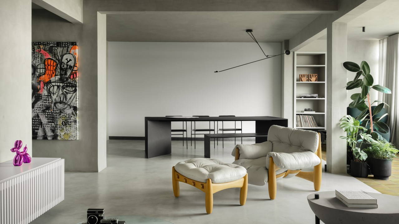 Minimalista: apê de 300 m² utiliza poucas cores e efeitos de luz no décor. Projeto de Lucas Lage. Na foto, sala de estar e jantar preto e branca, com mesa, poltrona e quadro.