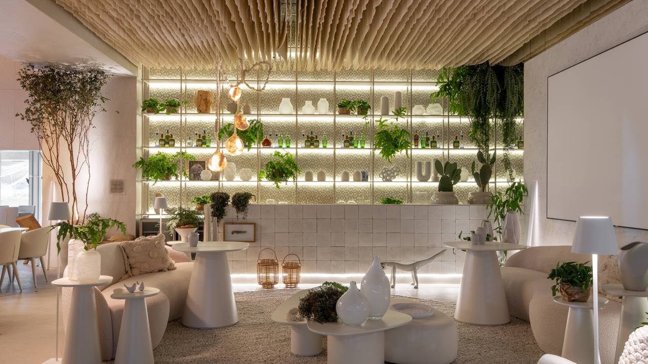 Restaurante grego em SP é inspirado na arquitetura de Mykonos. Projeto de Carla Felippi para a CASACOR São Paulo 2023. Na foto, bar com estante, cortinas no teto e móveis curvos.