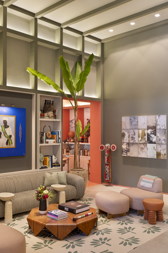 ritmo-alegria-samba-inspiram-casa-paleta-de-cores-vibrante-marcelo-salum-casacor-sp-2023-05 Sala de estar com parede verde, sofá baixo branco com listras verdes e mesa de centro de madeira.