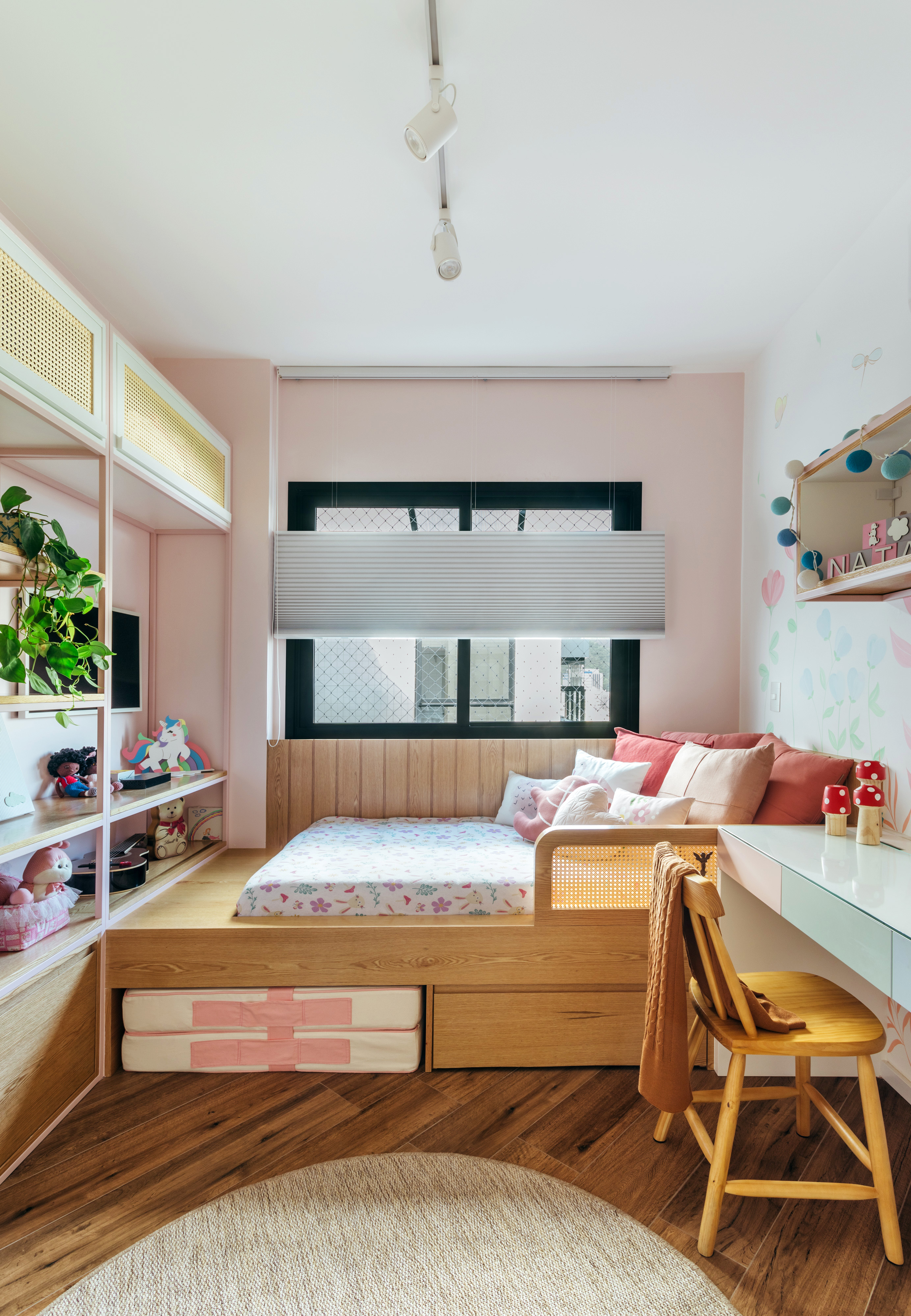 Quarto infantil com pintura na parede e cama de solteiro em plataforma de madeira.