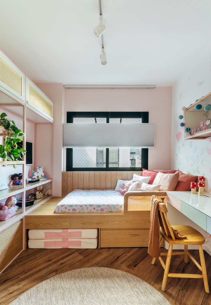 Quarto infantil com pintura na parede e cama de solteiro em plataforma de madeira.