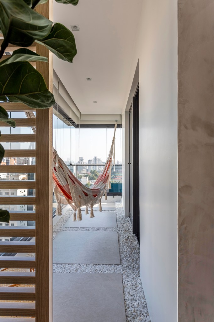 Apartamento ganha canto zen com rede de balanço e chão de pedriscos. Projeto de Interni Arquitetura. Na foto, varanda com canto zen, rede e pedriscos.