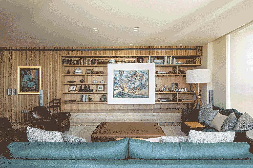 Sala de estar com estante de madeira com quadro que desliza escondendo a tv.