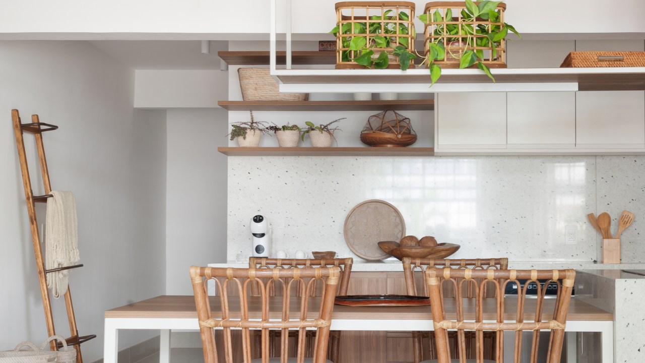 Projeto de Ricardo Melo e Rodrigo Passos. Na foto, cozinha integrada com ilha, mesa de jantar embutida e cadeiras de rattan.