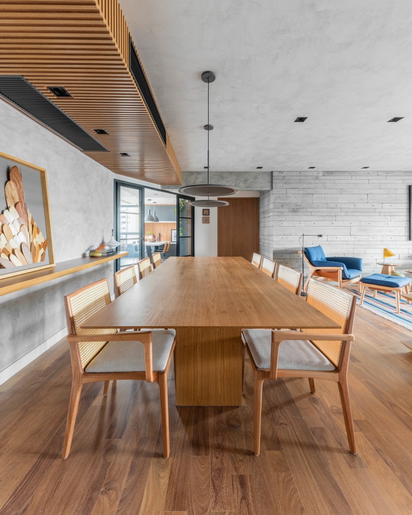 Projeto de Pietro Terlizzi. Na foto, sala de jantar com mesa de madeira e bancada de madeira suspensa na lateral.