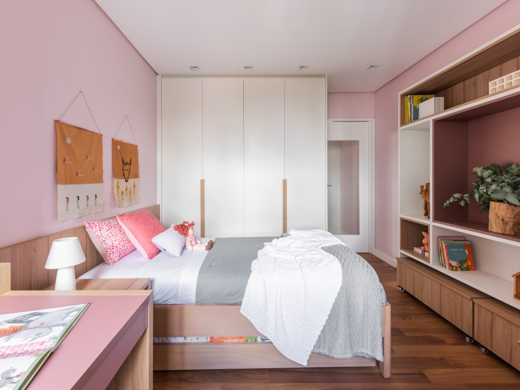 Projeto de Pietro Terlizzi. Na foto, quarto infantil com parede rosa, cama e bancada de estudos.