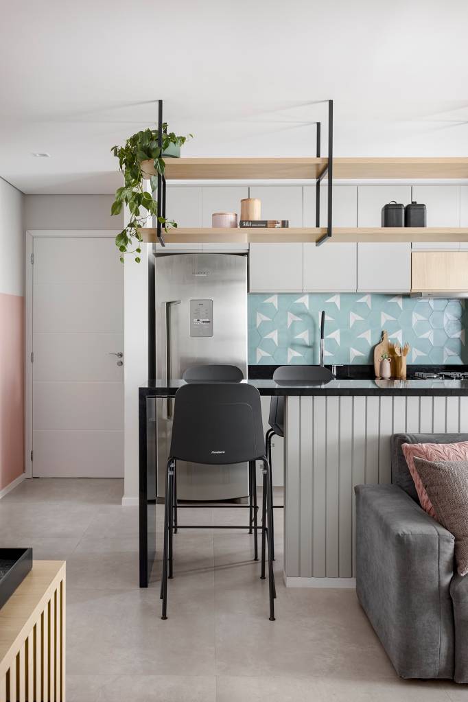 Apê de 84 m² ganha décor delicado em tons de azul, verde e rosa. Projeto de Dani Espírito Santo. Na foto, sala e cozinha integrada, balcão ripado e prateleira suspensa.