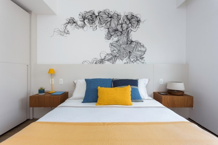 Quarto com cama de casal e urban art personalizada na parede.