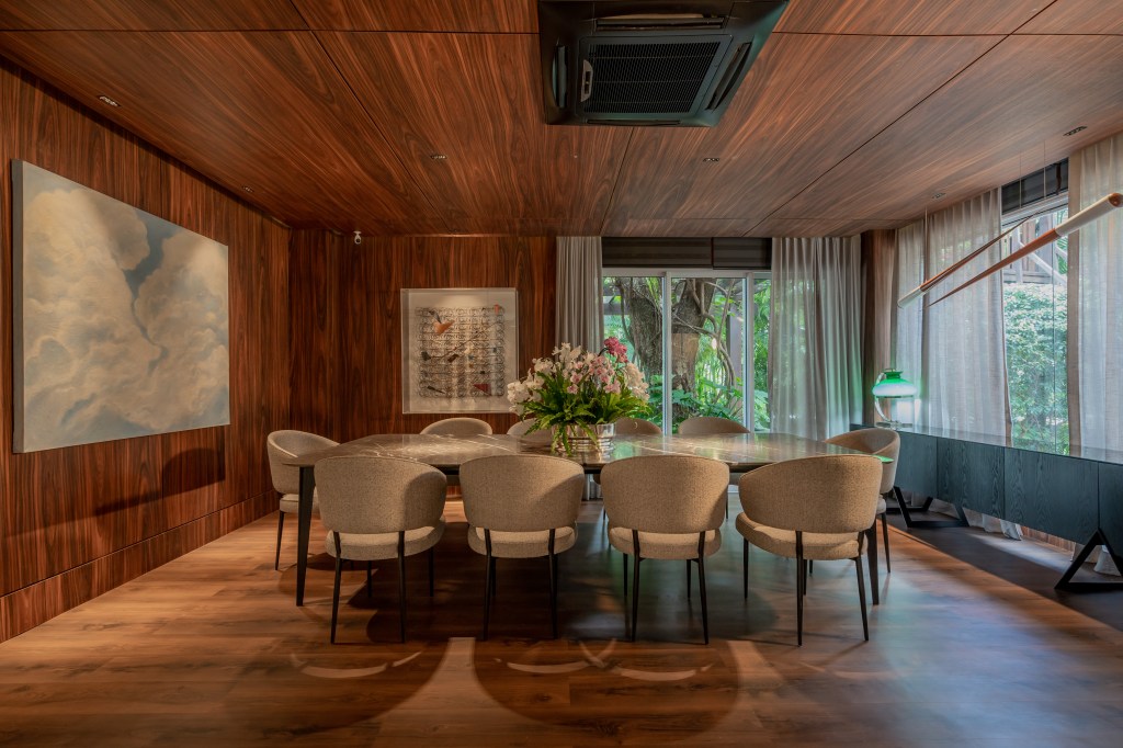 Projeto de Romário Rodrigues Arquitetos. Na foto, sala de jantar com piso e paredes em madeira com mesa de jantar retangular.