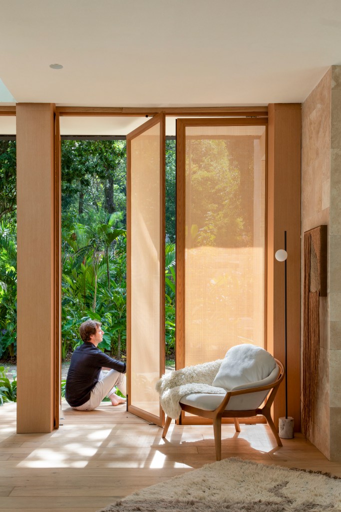 Casa de campo de 105 m² no meio da natureza é feita com três contêineres. Projeto de Up3 Arquitetura para a CASACOR Rio de Janeiro 2023, Na foto, porta com brises de madeira.