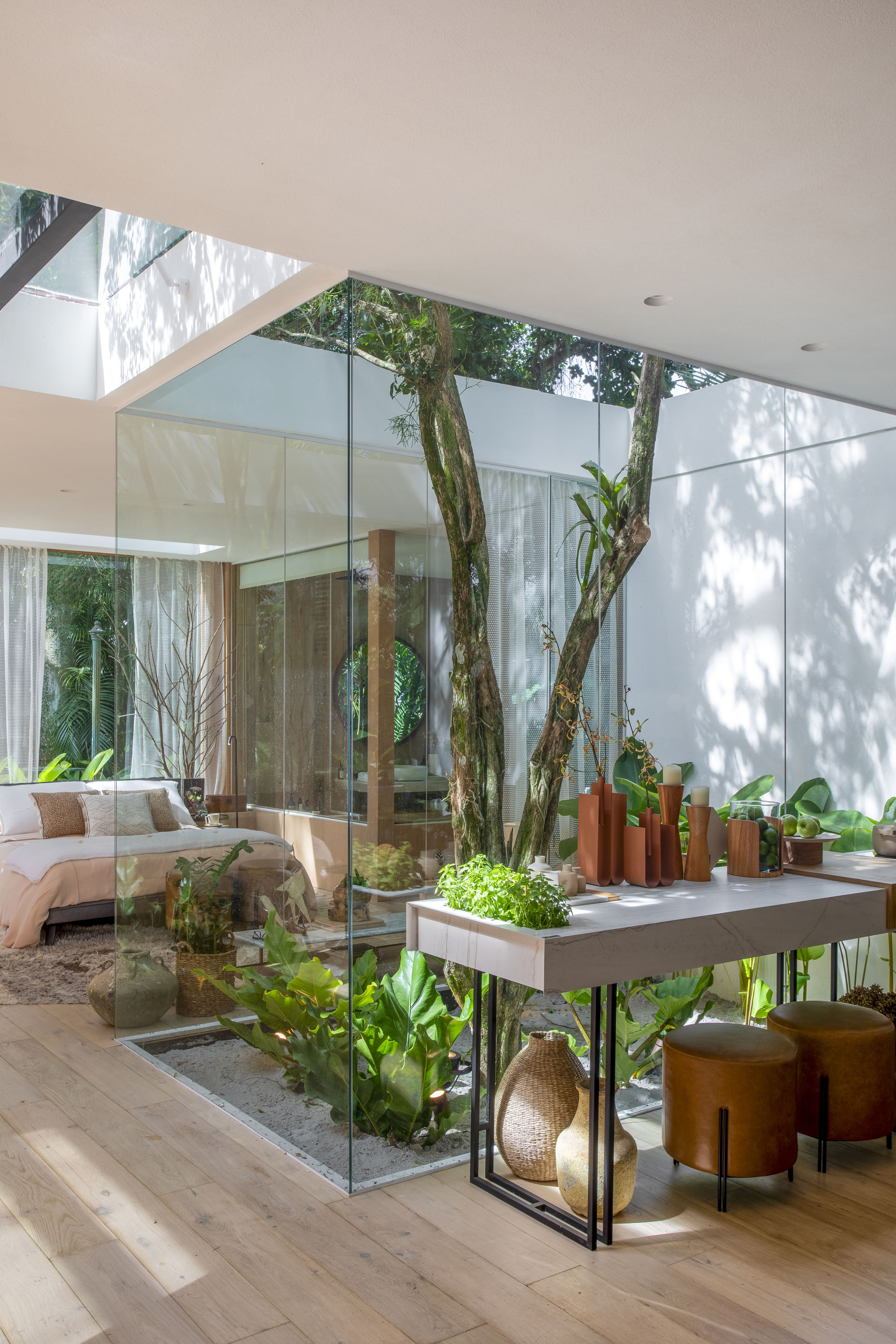 Casa de campo de 105 m² no meio da natureza é feita com três contêineres. Projeto de Up3 Arquitetura para a CASACOR Rio de Janeiro 2023, Na foto, quarto de casal com parede e teto de vidro, jardim interno e aparador.