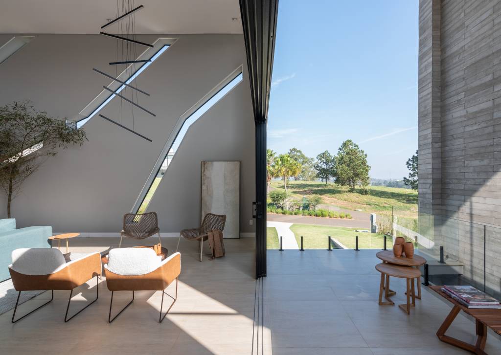 Sala minimalista com piso de porcelanato, pé-direito alto e poltrona branca.