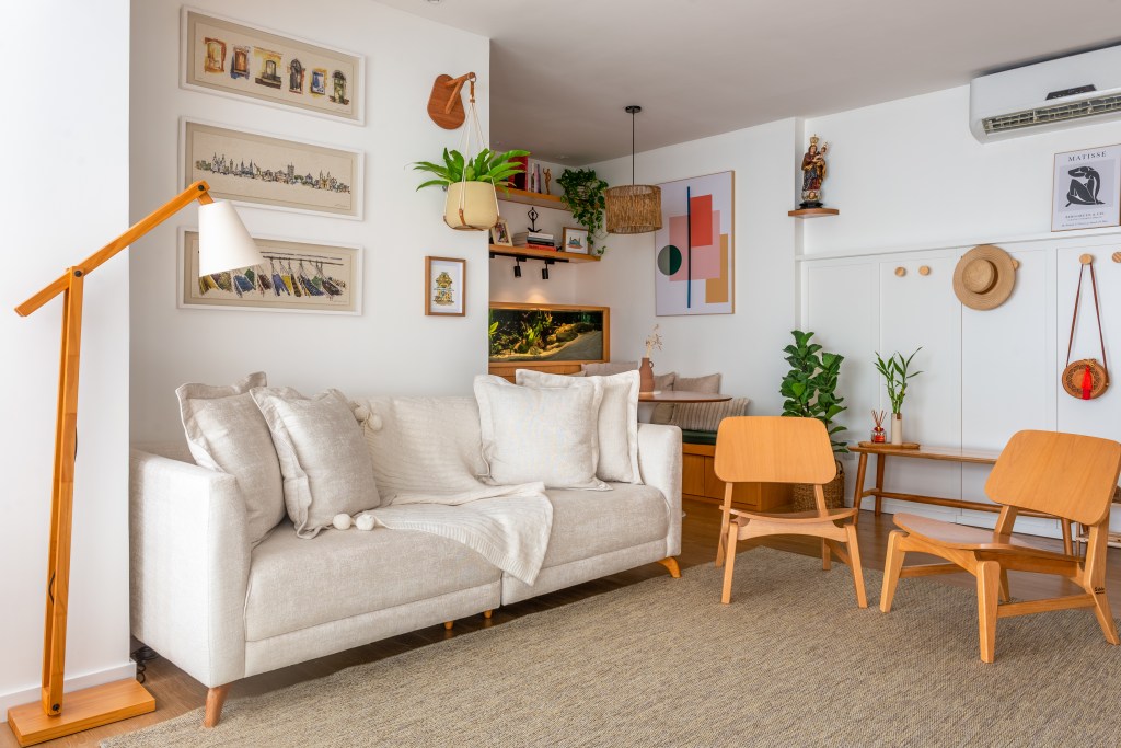 Projeto de Djanira Cabral. Na foto, sala com tapete bege, sofá branco, luminária de piso.