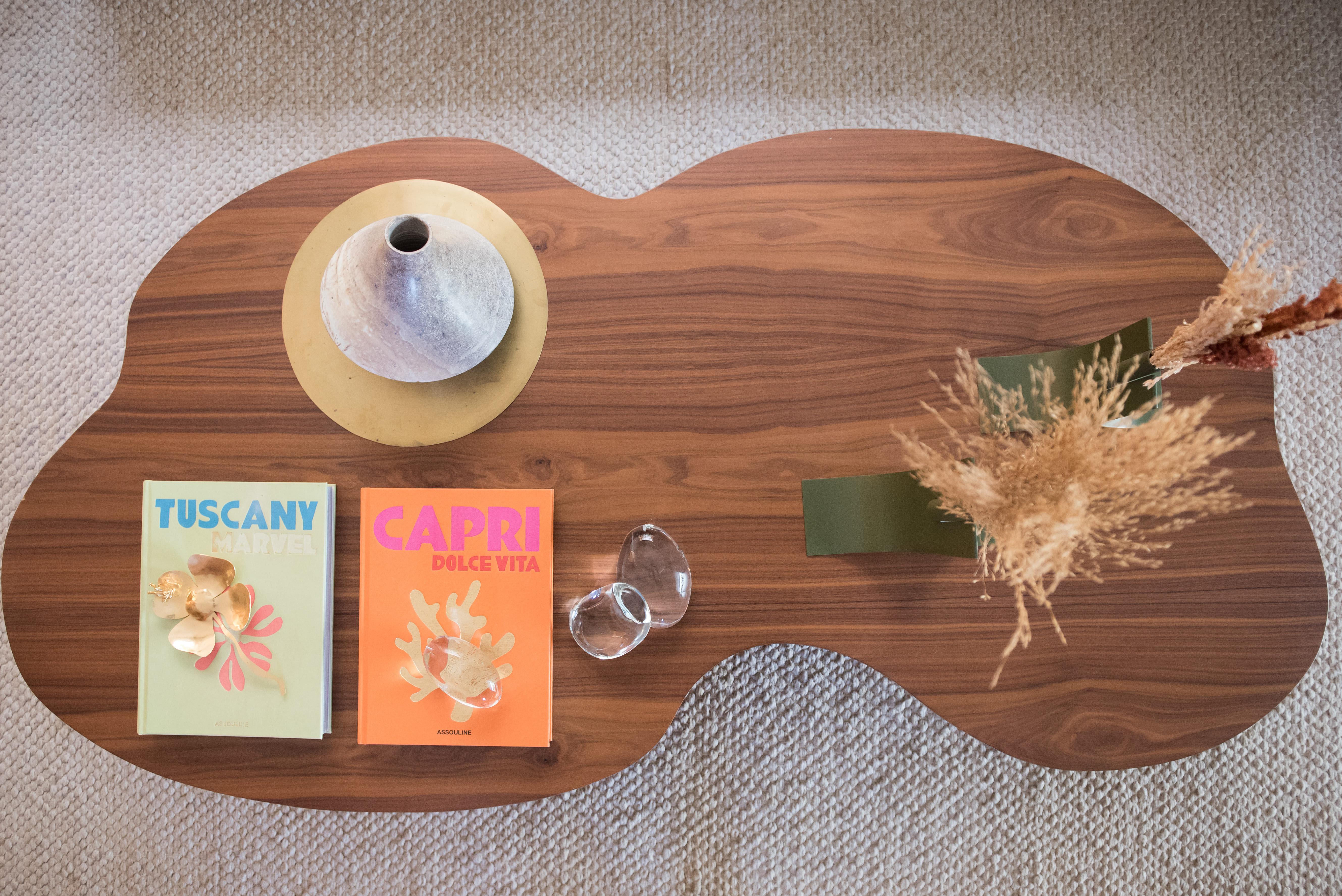 Sala de estar com paleta bege e mesa de centro de madeira com formato orgânico.